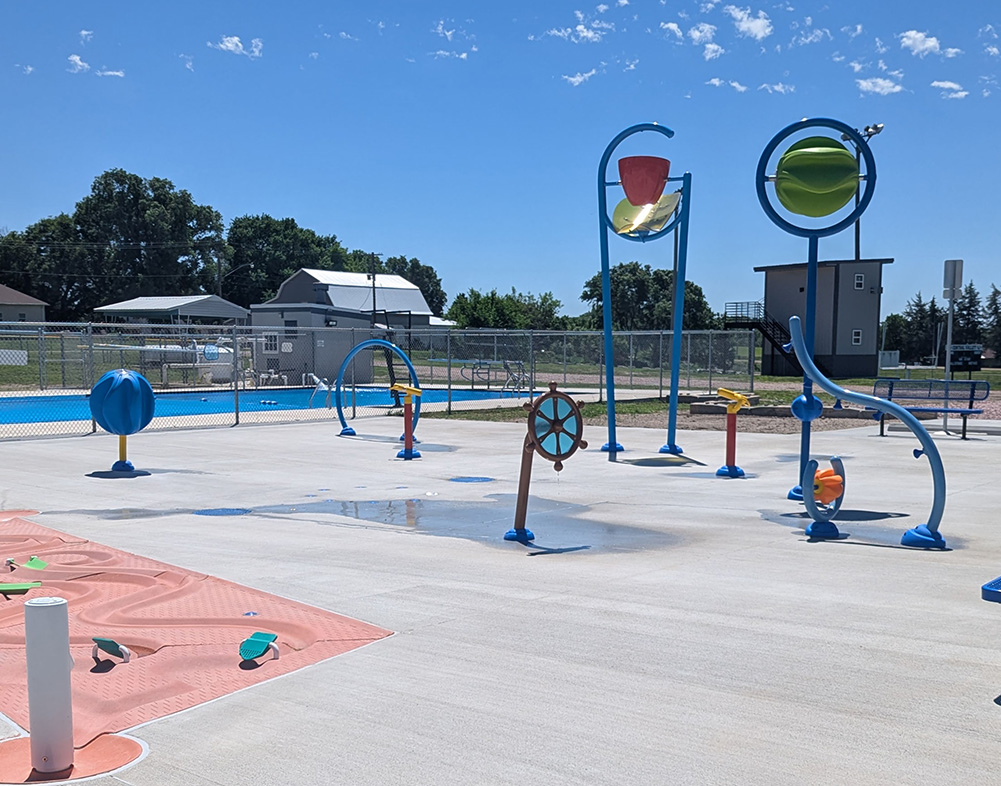 view of splash pad next to pool in wolbach